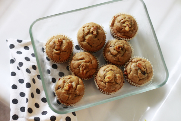 A rectangle glass dish full of peanut butter chocolate chip banana bread muffins sitting on a poka dot dishcloth