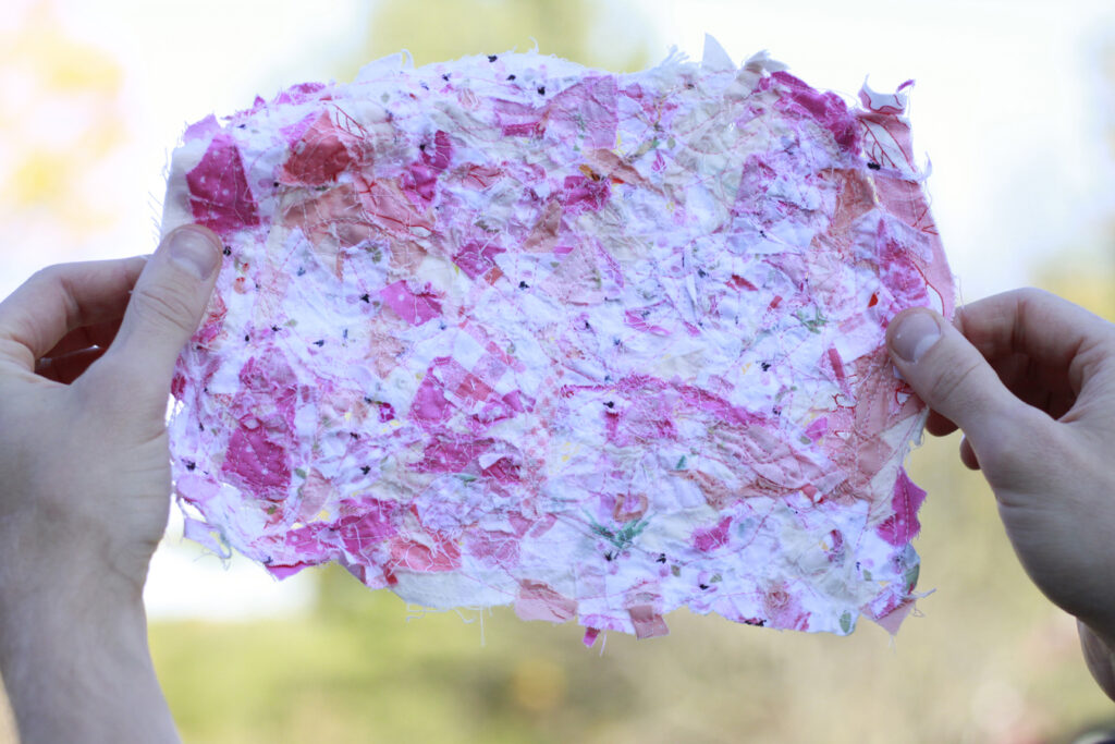 Hot pink, light pink scraps sewn together in one piece held up by hands