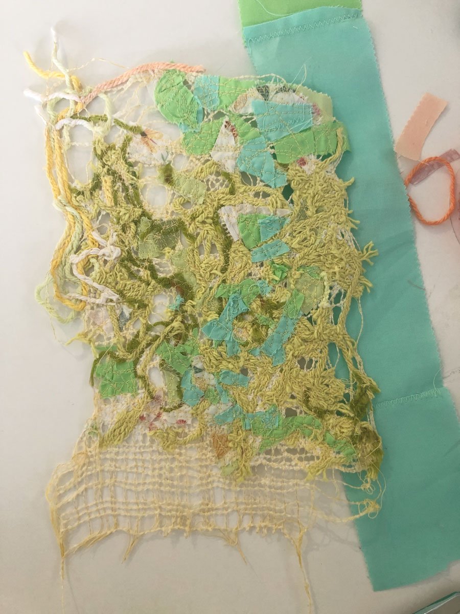 light green, dark green, teal and coral fabric scraps, cotton yarn all sewn together 