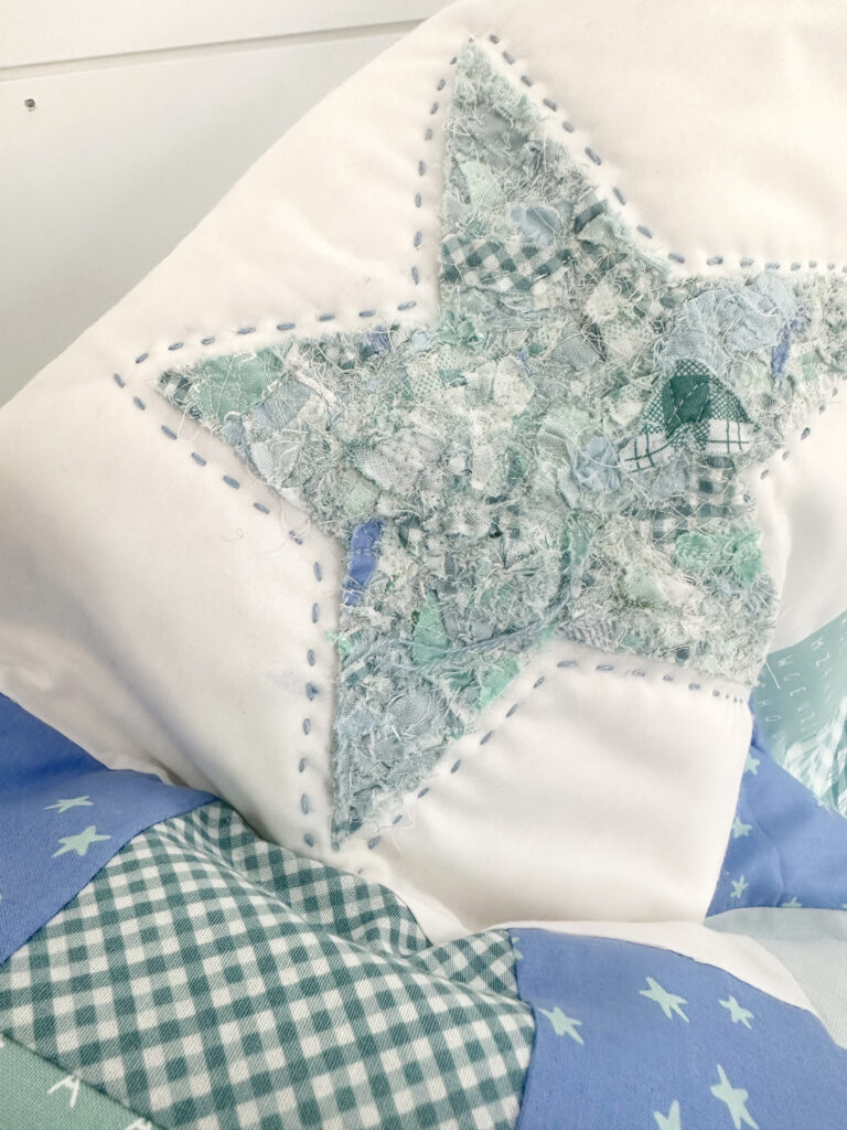 A star made of scrap fabric outlined in chunky stitches on a white square.
